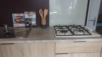 Una cocina moderna con estufa a gas, armarios de madera y horno empotrado.