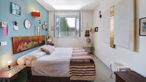 Une chambre à coucher avec un lit, une fenêtre et divers éléments de décoration murale.