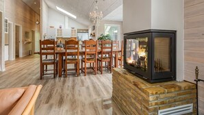 Een modern interieur met een eethoek, keuken en open haard.