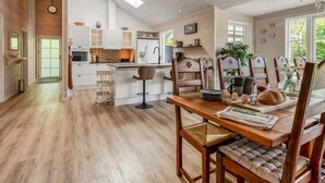 Een ruime keuken met houten vloeren, witte kastjes en een centraal eiland.