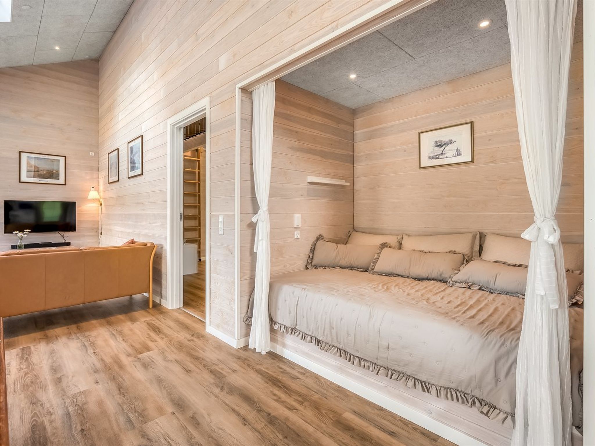 Un dormitorio con cama, televisor, escritorio y armario.