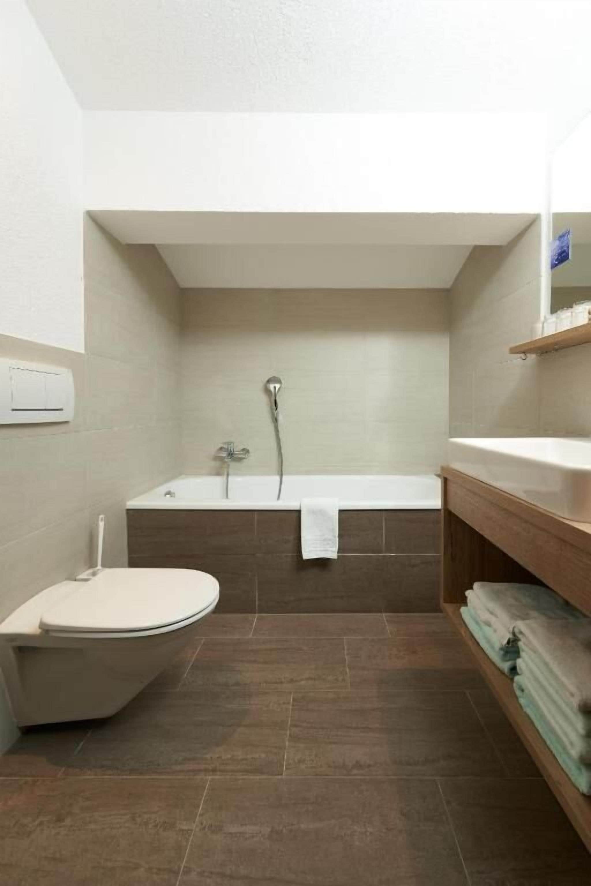 A bathroom with a toilet, bathtub, and sink.