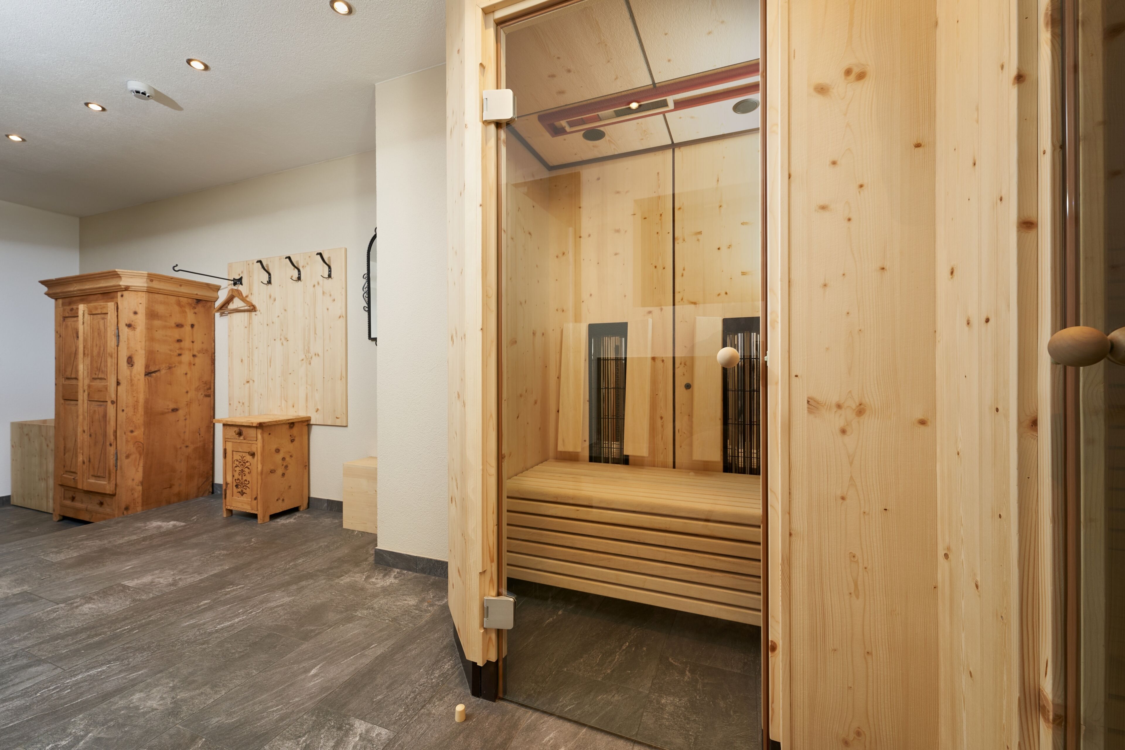 Un sauna de madera con bancos y un armario de madera.