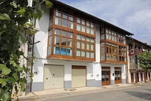A two-story building with large windows and a balcony. - Apartamentos Irati Olaldea (Oroz Betelu)