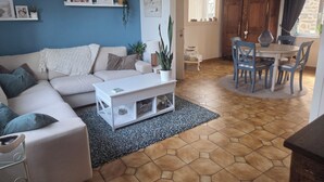 Un salon comprenant un canapé, une table basse et un coin repas avec des chaises et une table.
