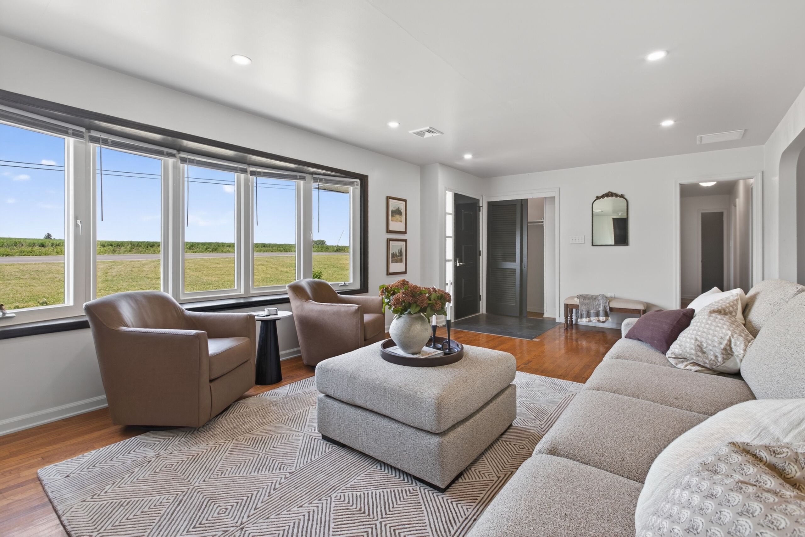Bright living room with panoramic windows, plush seating, and open views