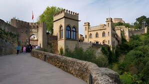 A historic stone bridge leading to a castle with arched windows and a flag. - Holiday Home 'Cova Negra Nature' with Mountain Views, Shared Pool, and Air Conditioning (El Genovés)