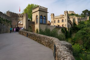 A historic stone bridge leading to a castle with arched windows and a flag. - Holiday Home 'Cova Negra Nature' with Mountain Views, Shared Pool, and Air Conditioning (El Genovés)