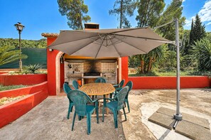 An outdoor patio with a brick oven, a table, and chairs.