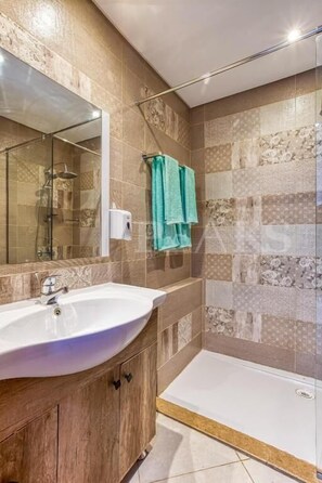Ein modernes Badezimmer mit Duschkabine aus Glas, Waschbecken und Toilette.