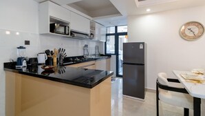 Een moderne keuken met een centraal eiland, een ingebouwde magnetron en roestvrijstalen apparatuur.