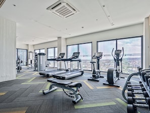 Un gimnasio con cintas de correr, elípticas y bancos de pesas.