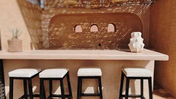 A bar area with a counter and three stools.