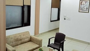 Una sala de estar con sofá, sillón, mesa de centro y ventilador de techo.