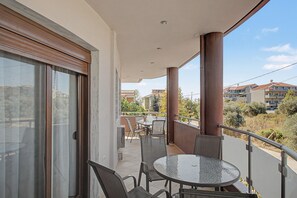 A balcony with a glass door, a round table, and two chairs. - Apartment '2' with Mountain View, Shared Garden and Wi-Fi (Limenaria)