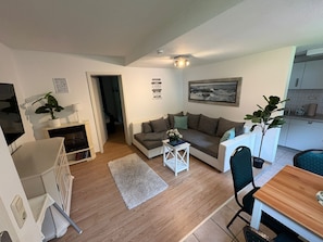 Ein Wohnzimmer mit einer Couch, einem Couchtisch und einem Essbereich mit Tisch und Stühlen.