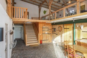 Un interior de madera con una escalera, puertas de madera y un comedor.