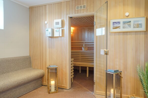 A wooden interior with a sauna, a bench, a glass door, and a framed picture on the wall. - Apartment for 2 in the historic Haubarg near St. Peter-Ording (Tating)