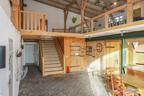 Ein Holzinnenraum mit einer Treppe, Holztüren und einem Essbereich.