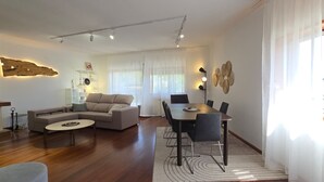 A modern living room with a sofa, coffee table, dining table with chairs, and a fireplace. - XL house for large tribes in the heart of nature, quick access to Parc Gerês (Braga)