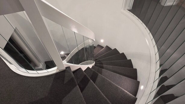 A spiral staircase with glass railings and carpeted steps. - Panoramic View in Narre Warren North (Melbourne)