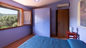 Una camera da letto con un letto, un armadio, una finestra e opere d'arte.
