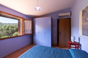 Ein Schlafzimmer mit Bett, Schrank, Fenster und Bildern.