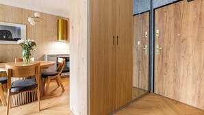 Un intérieur moderne avec une table à manger en bois, des chaises, un vase de fleurs et une grande armoire en bois.