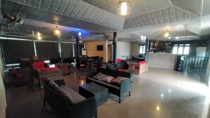 Un amplio salón con muebles modernos, techo alto y una zona de bar.