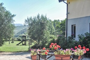 A garden with potted plants, a playground, and a building with a window. - Case a Stratola (Montella)