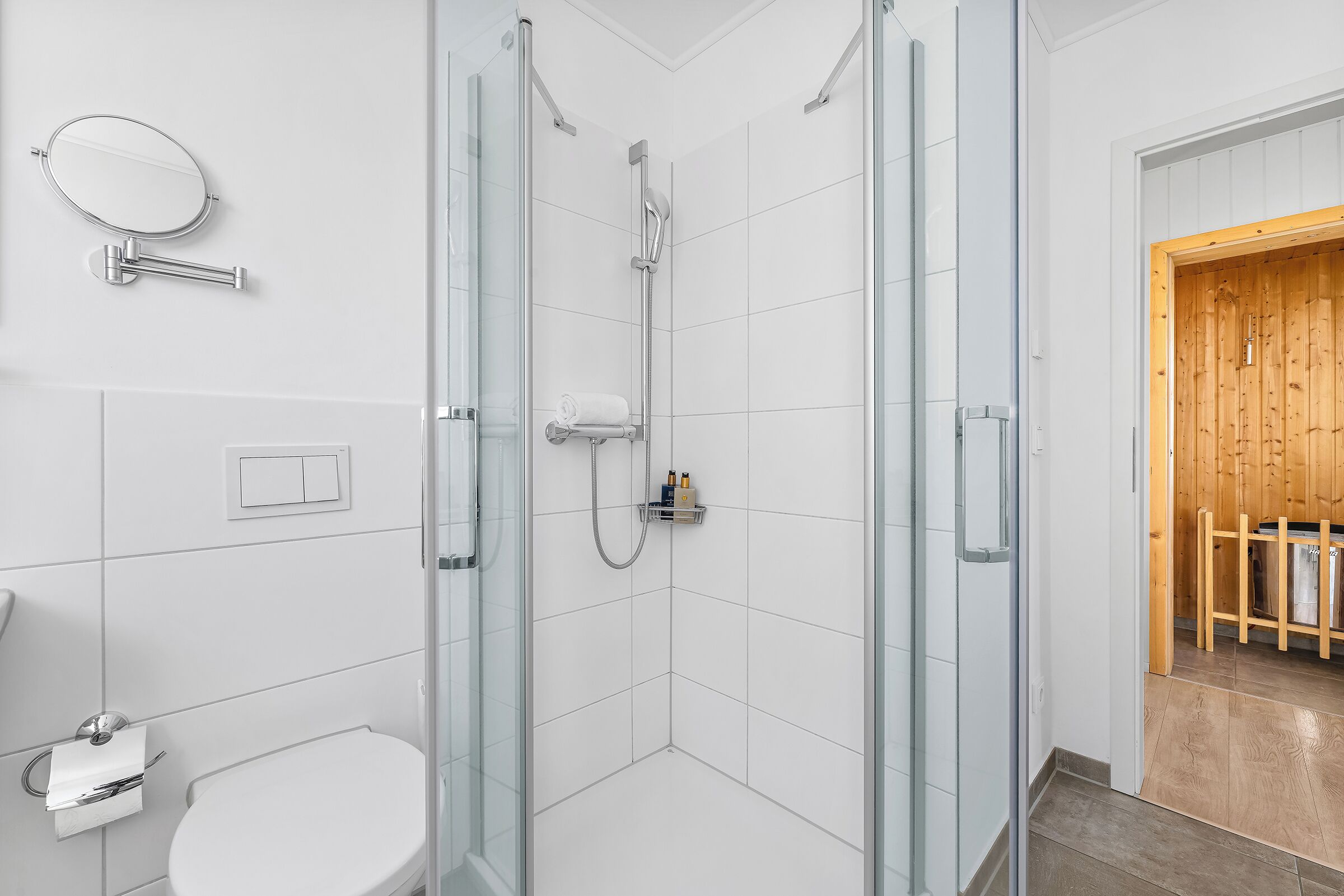 Un baño moderno con ducha de vidrio, inodoro y lavamanos.