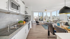 Eine moderne Küche mit integriertem Mikrowellenherd, einer Edelstahl-Spüle und einem Essbereich mit Tisch und Stühlen.
