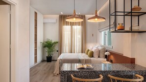 Uma sala de estar moderna com uma ilha central, cadeiras de madeira, um sofá e uma mesa de jantar.
