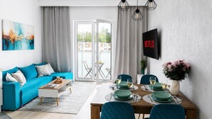 A modern living room with a sofa, dining table, and chairs.