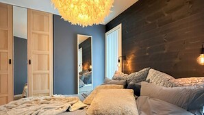 A bedroom with a large bed, a mirror, and a unique ceiling light fixture. - Architect drawn home with amazing view over Nisser (Treungen)