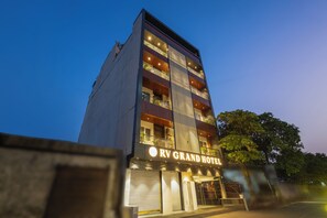 Un hotel de varios pisos con un cartel llamativo que dice 'RV GRAND HOTEL'.