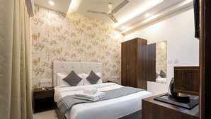A hotel room with a bed, nightstand, wardrobe, and a mirror. - Rv Grand Varanasi (Varanasi)