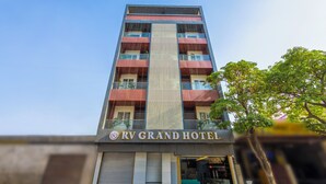 A tall hotel building with a prominent vertical stripe design, balconies, and a clear sky. - Rv Grand Varanasi (Varanasi)