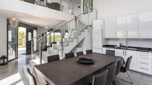 Een moderne keuken met een eethoek, een trap en uitzicht op de omgeving.