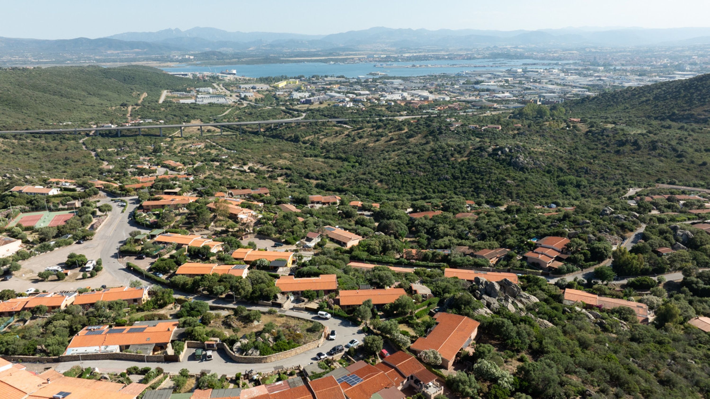 Vue aérienne d’un quartier résidentiel avec des maisons, des routes et un pont.