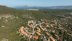 An aerial view of a coastal residential area with houses, a swimming pool, and a bridge. - Casa del Vento by Wonderful Italy (Olbia)