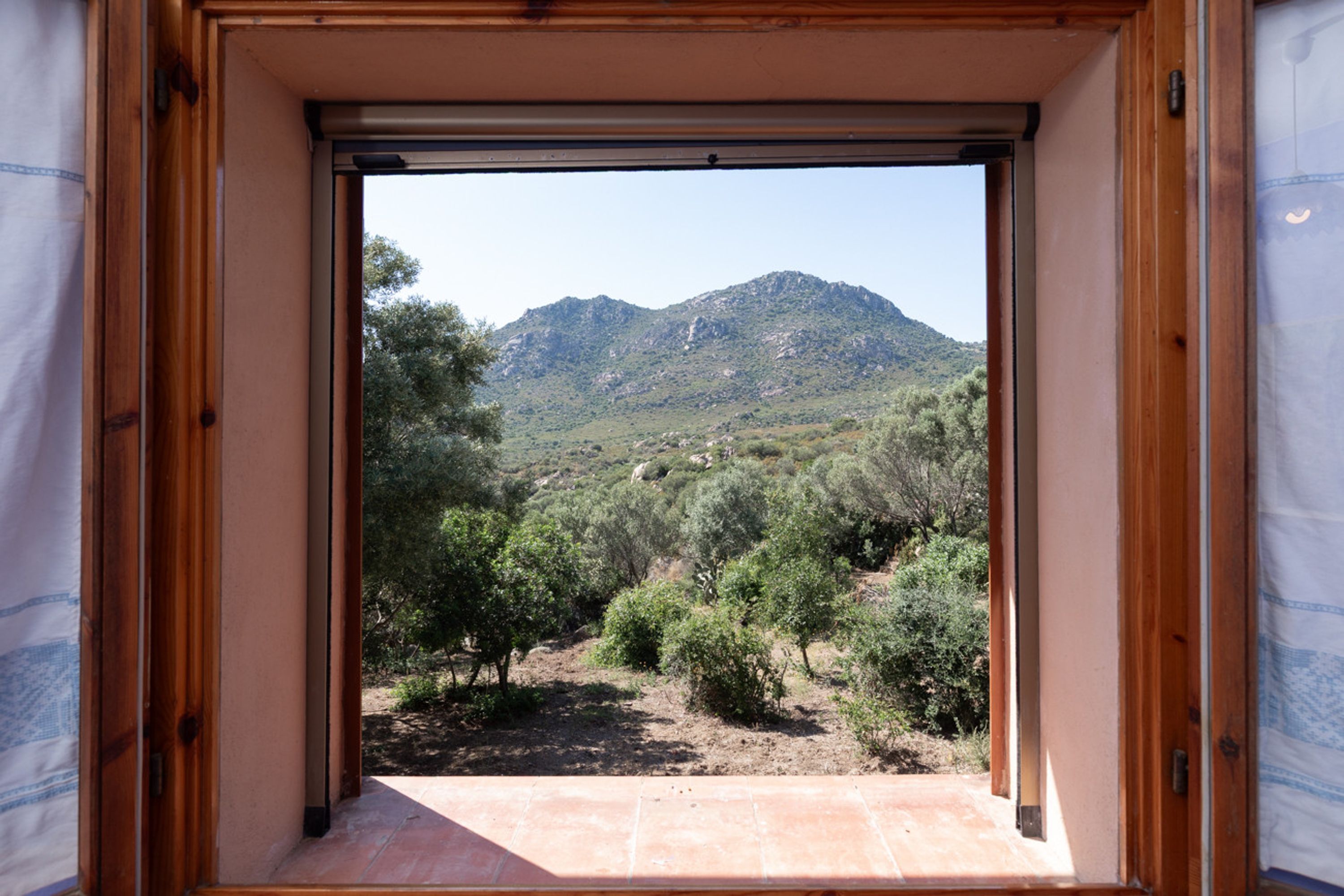 A room with a wooden frame and a view of a mountainous landscape.