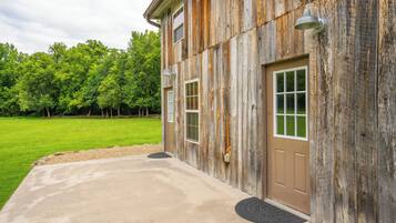 A rustic building with a concrete driveway and a wooden door.