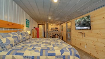 Ein Zimmer mit einem Bett, einer Holzwand, einer Küchenzeile und einem Schild, das die Stadtgrenze kennzeichnet.