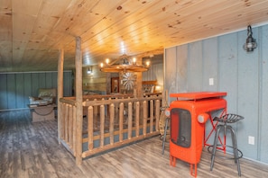 A rustic interior with a wooden ceiling, a wooden fence, a vintage radio, and a bar area with stools. - TBarnLoft@FF: Honeymoon, Outdoor Fireplace, Wifi, Water View, Large Yard (Cosby)