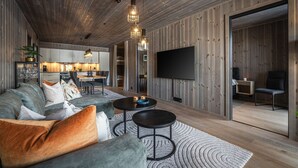 Ein modernes Wohnzimmer mit einer Couch, einem Couchtisch und einem Fernseher.