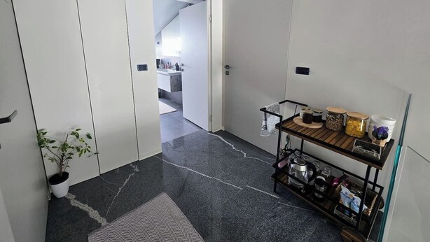 Un couloir avec une plante en pot, un coin café et une vue sur une cuisine.