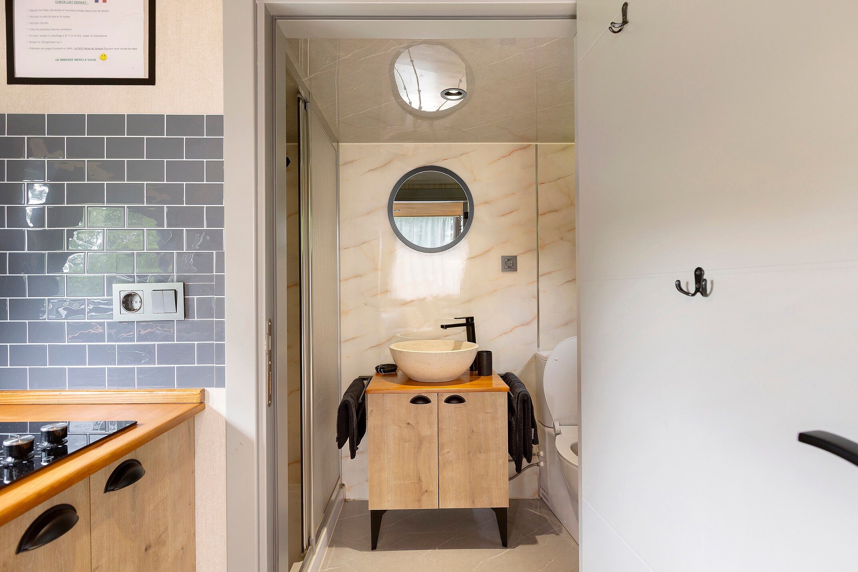 A bathroom with a sink, mirror, and towel rack.
