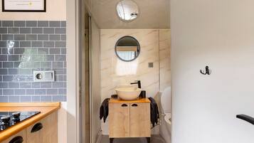 A bathroom with a sink, mirror, and towel rack.