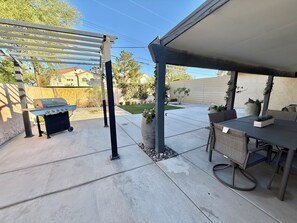 A patio with a grill, outdoor furniture, and a pergola. - House in Las Vegas, NV  (North Las Vegas)